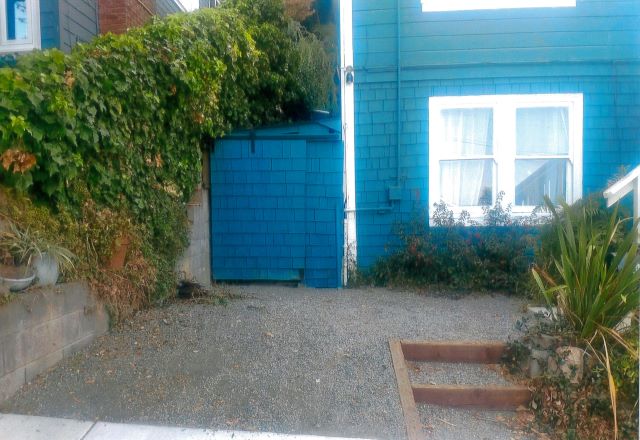 After: Completed view of a gravel driveway and a sliding gate to the side yard.